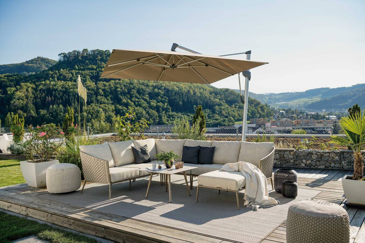 Superheld: Der grosse Schirm «Sombrano S+» richtet sich beim Öffnen über die Kurbel direkt horizontal aus. Dank des seitlich sitzenden Masts lassen sich die Möbel gut arrangieren. Hunn Gartenmöbel.