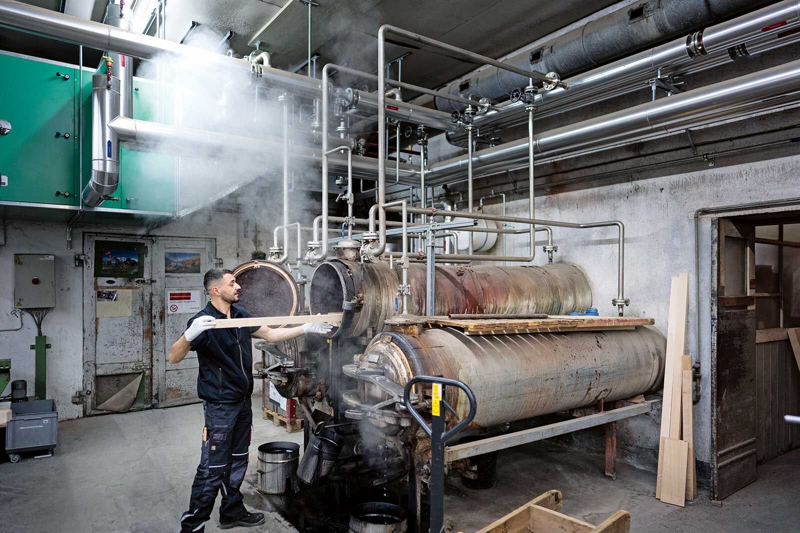 Das Holz wird mit Dampf bearbeitet, bevor es in der Biegemaschine seine Form annimmt.