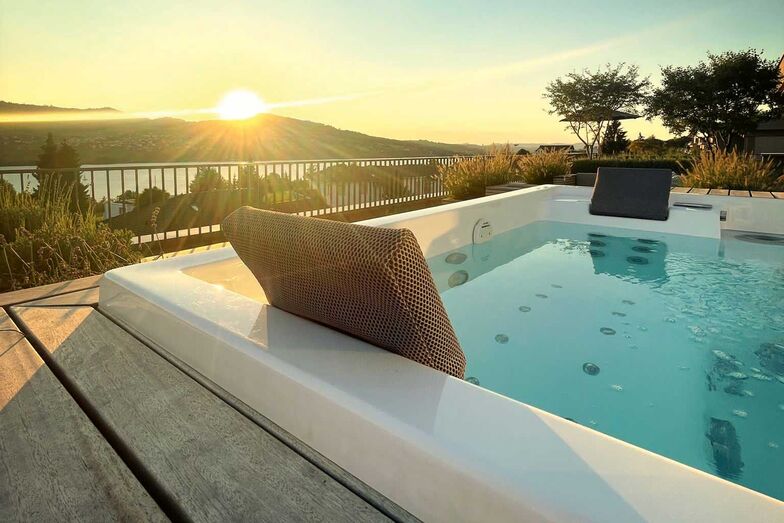 Ein Whirlpool der Marke Riviera Pool wurde in ein Gesamtkonzept mit Holzlounge und Pflanztrögen integriert. Linz & Partner Schwimmbadtechnik GmbH, www.poolz.ch