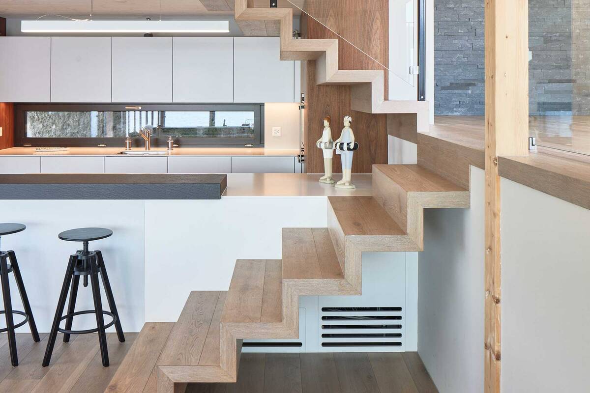 Ein altes Bootshaus wurde zum kleinen, aber feinen Wohnhaus am See. Die engen Platzverhältnisse erforderten eine schlanke Lösung: Die «fliegende Treppe» ohne Wangen und Abstützungen wirkt sehr leicht und integriert sich mit Stufen aus dem gleichen mehrschichtigen Eichenparkett gut in den Wohnraum. Hans Hassler AG.