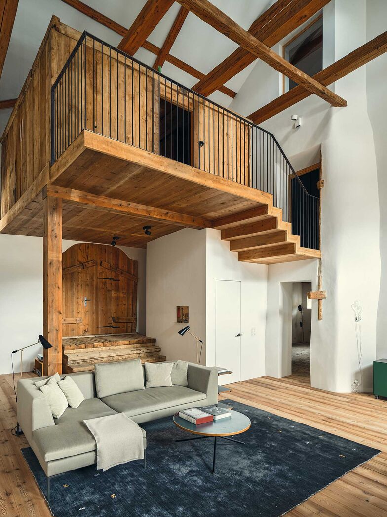 Ein Blickfang ist das Gästezimmer aus Altholz über dem Wohnbereich. Es mutet wie ein gemütliches Baumhaus an.