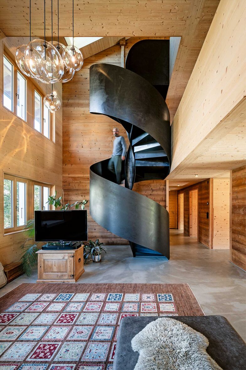 Die mächtige Wendeltreppe aus ­Rohstahl in das traditionelle Walliser­haus zu integrieren – dazu braucht es durchaus Selbstbewusstsein. Die Form mutet wie eine DNA-Doppelhelix an und passt zu dem Wissenschaftler-Paar, das mit seinen Kindern das Haus bewohnt.