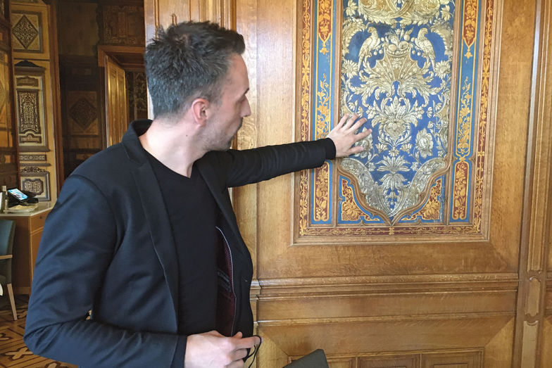 Hotelier Roger Lehmann weist auf die prunkvollen Ledertapeten aus Pariser Manufakturen hin.