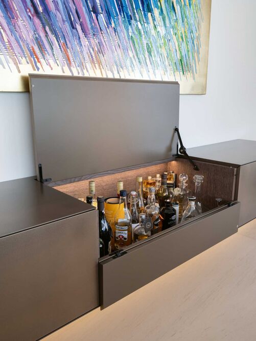 Elegant verstaut: Von Ken Adam mit seinen futuristischen und zeitlosen James-Bond-Filmkulissen inspiriert, entstand das Konzept für den gesamten Umbau der Wohnung. Die hochwertige Materialisierung und das schlichte und reduzierte Design zeichnen das Objekt aus. Eingesetzt wurden Eiche massiv, furniert sowie dunkel gebeizt, die Keramik «Infinity Sahara Noir» und die goldbronzige «Midas»-Oberfläche. Stuber Team AG, www.stuberteam.ch