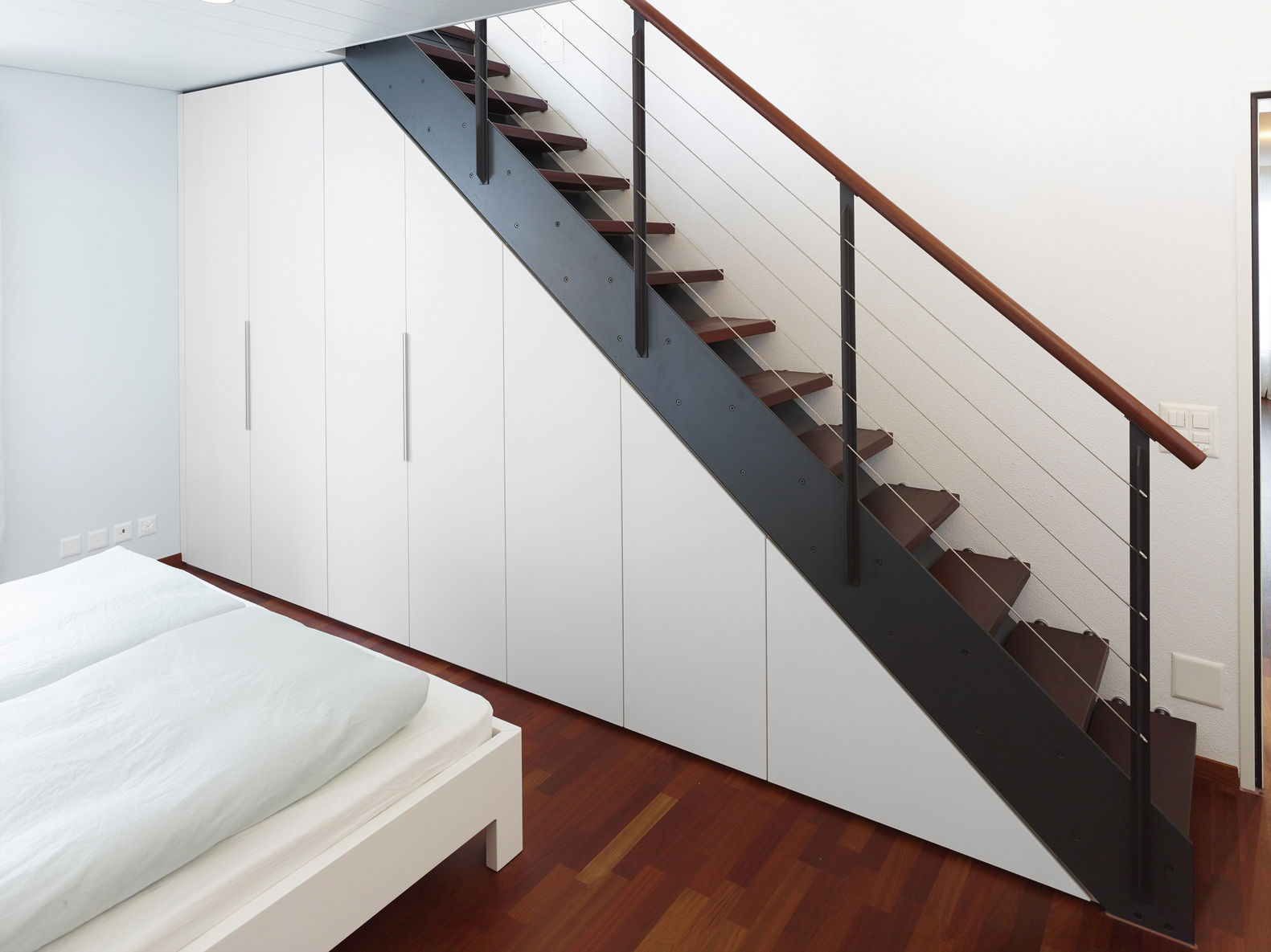 Dass der Raum unter der Treppe bis zur kleinsten Ecke perfekt genutzt werden kann, beweist dieses Beispiel. Die Schrankfronten erstrecken sich über den Sockel und die Blende. Alpnach Norm.
